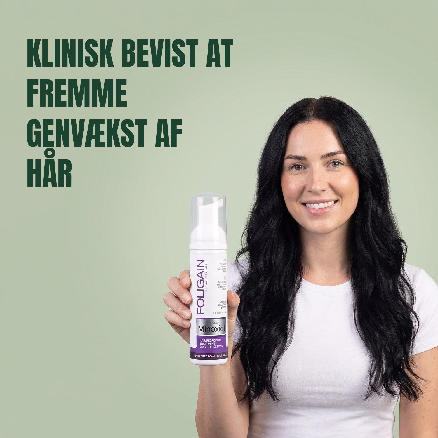 Woman holding the Foligain Minoxidil 2% foam can for women against a green background