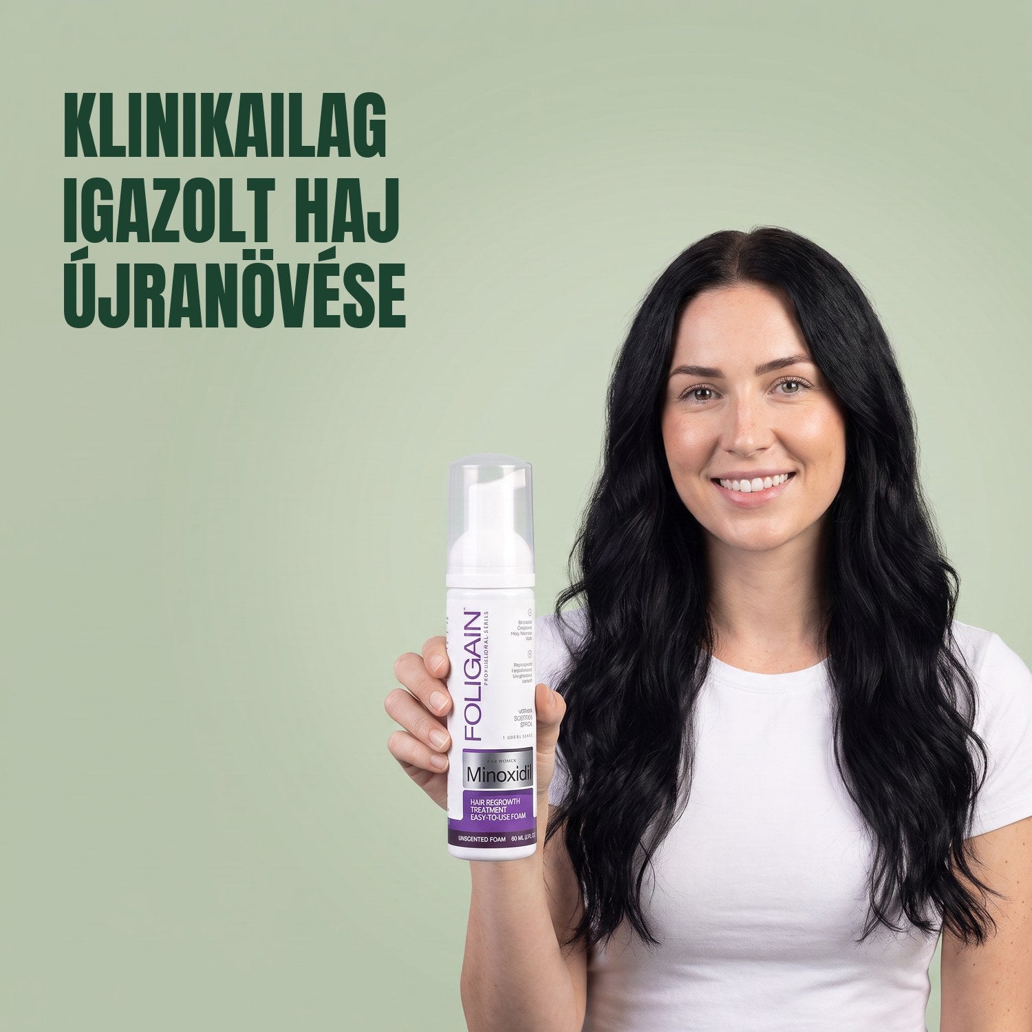 Nő tartja a Foligain Minoxidil 2% hab dobozát nőknek, zöld háttér előtt