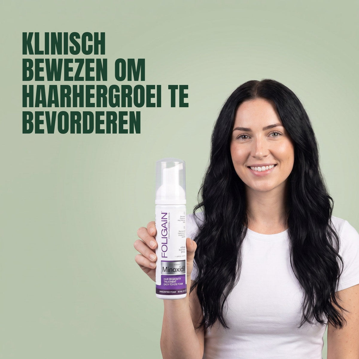 Woman holding the Foligain Minoxidil 2% foam can for women against a green background