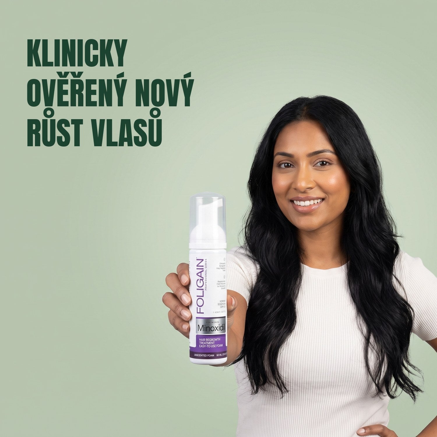 Žena drží pěnu Foligain Minoxidil 2% pro ženy na zeleném pozadí