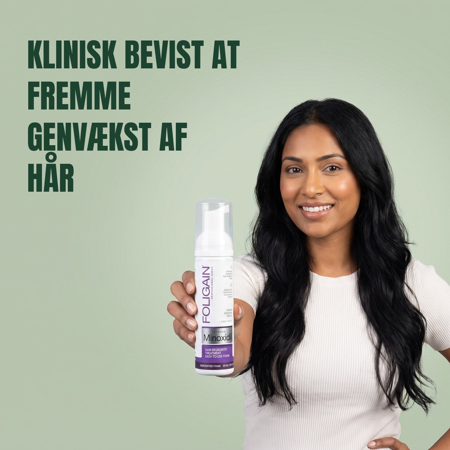 Kvinde holder Foligain Minoxidil 2% skum til kvinder mod en grøn baggrund