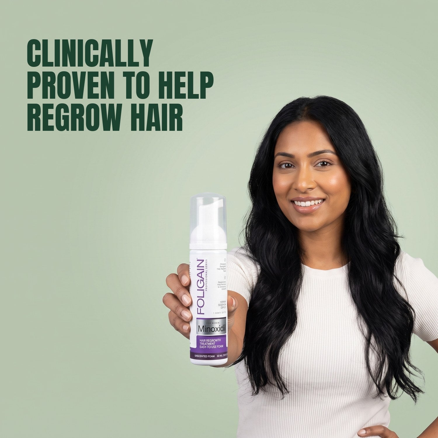 Woman holding Foligain Minoxidil 2% foam for women against a green background