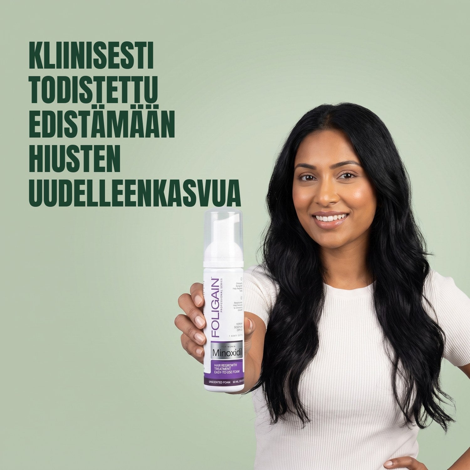 Nainen pitelee Foligain Minoxidil 2% -vaahtoa naisille vihreää taustaa vasten
