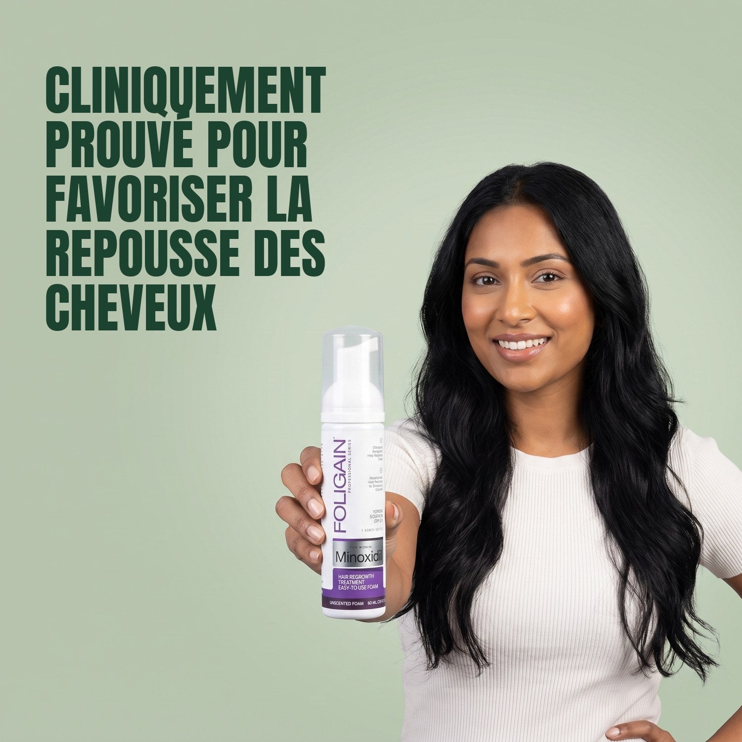 Woman holding Foligain Minoxidil 2% foam for women against a green background