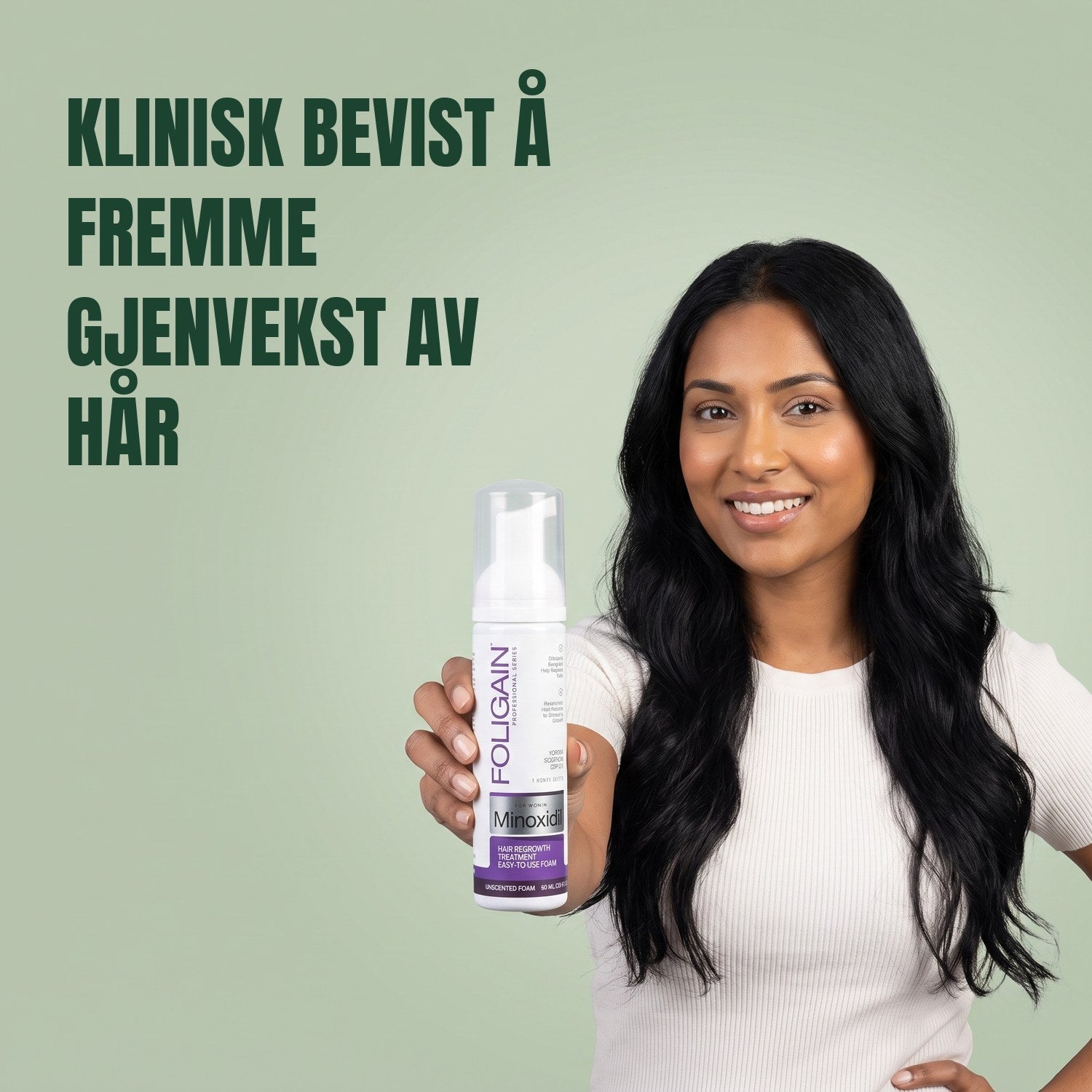 Kvinne som holder Foligain Minoxidil 2 % skum for kvinner mot en grønn bakgrunn