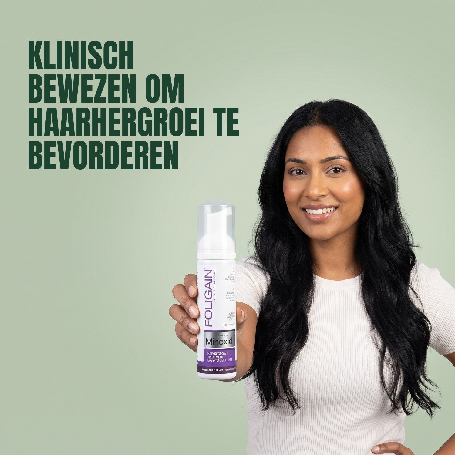 Woman holding Foligain Minoxidil 2% foam for women against a green background