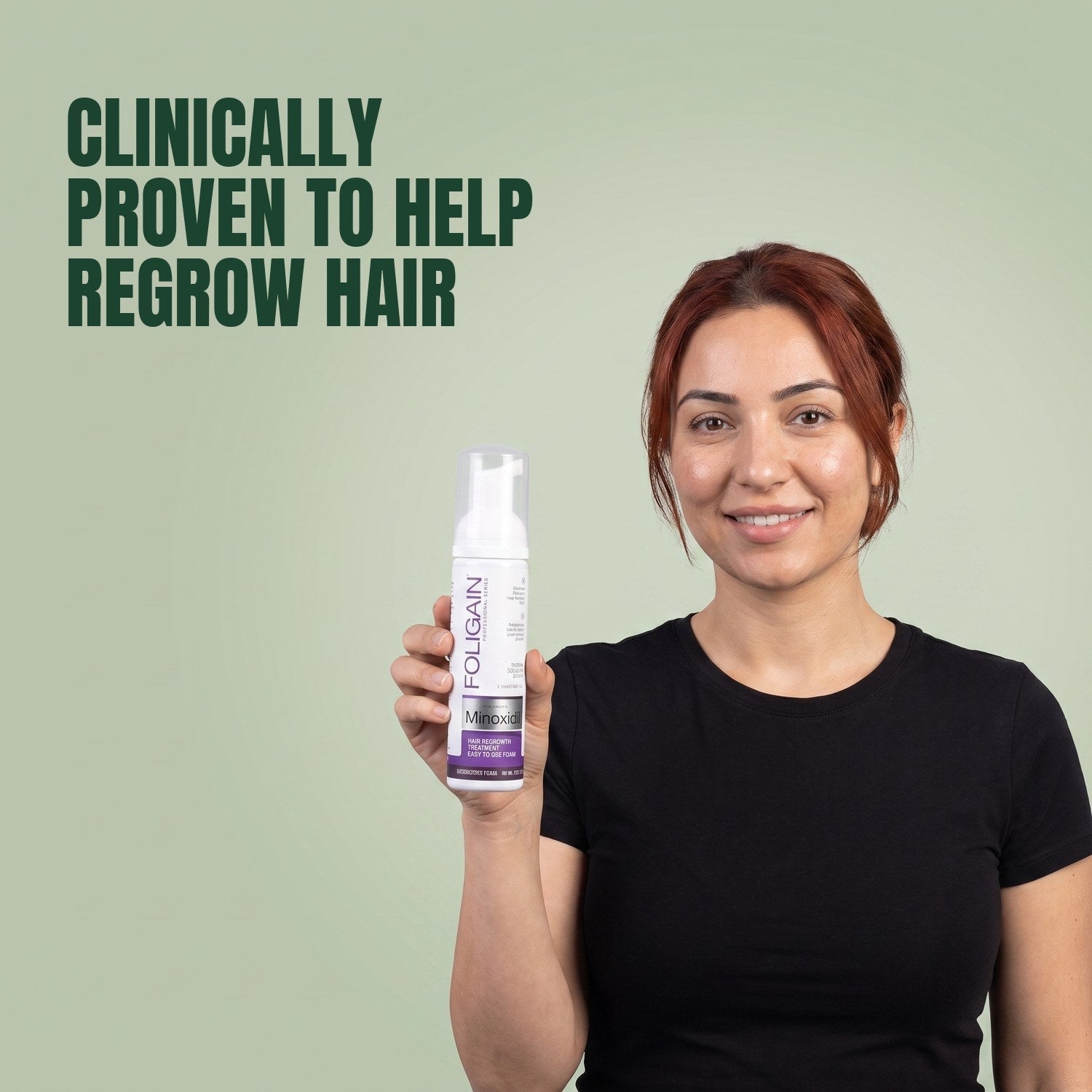 Woman holding the Foligain Minoxidil 2% foam can for women against a green background