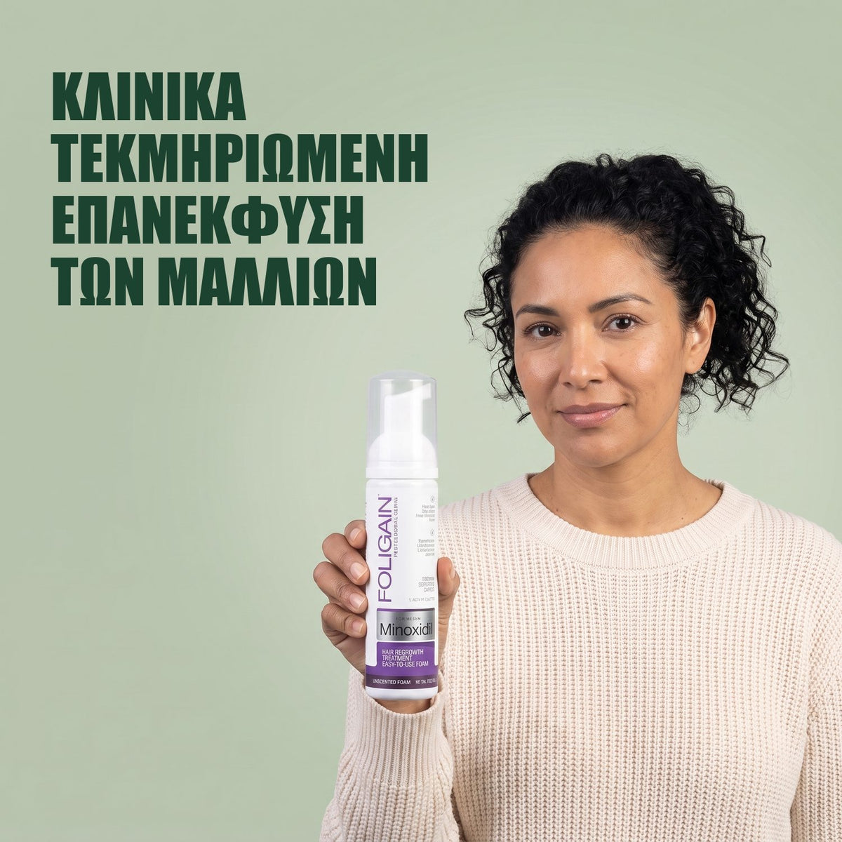Γυναίκα κρατά το δοχείο Foligain Minoxidil 2% αφρός για γυναίκες σε πράσινο φόντο