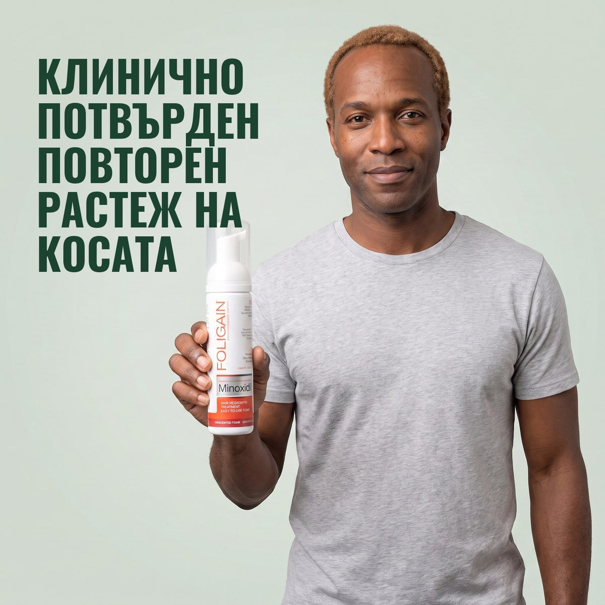 Мъж държи флакон Foligain миноксидил 5% пяна за мъже на зелен фон