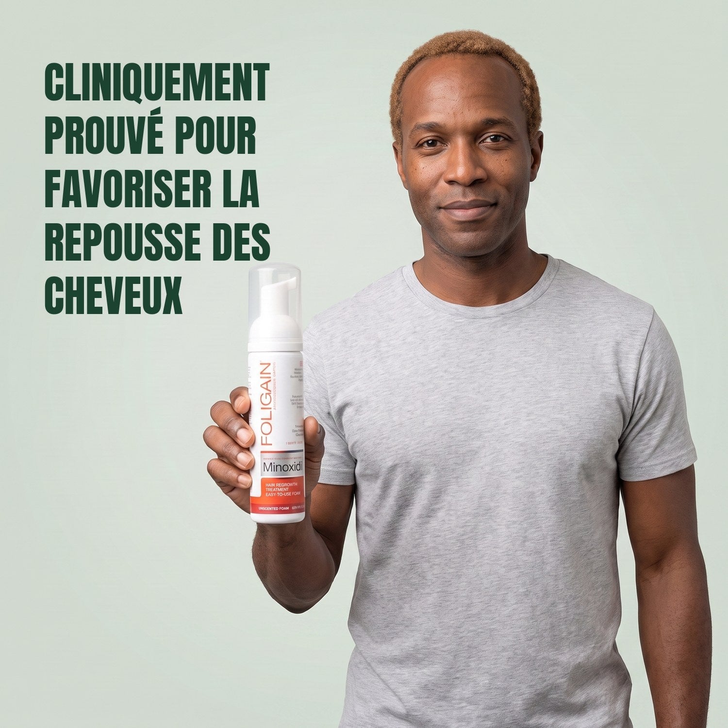 Man holding the Foligain Minoxidil 5% foam can for men against a green background