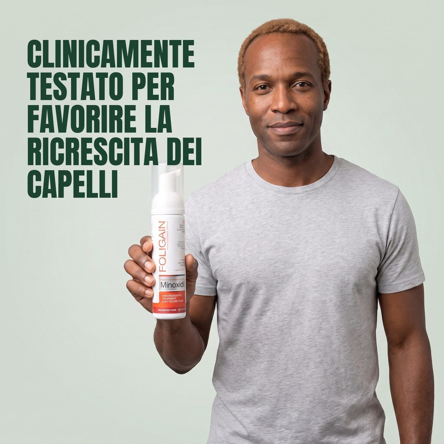 Man holding the Foligain Minoxidil 5% foam can for men against a green background