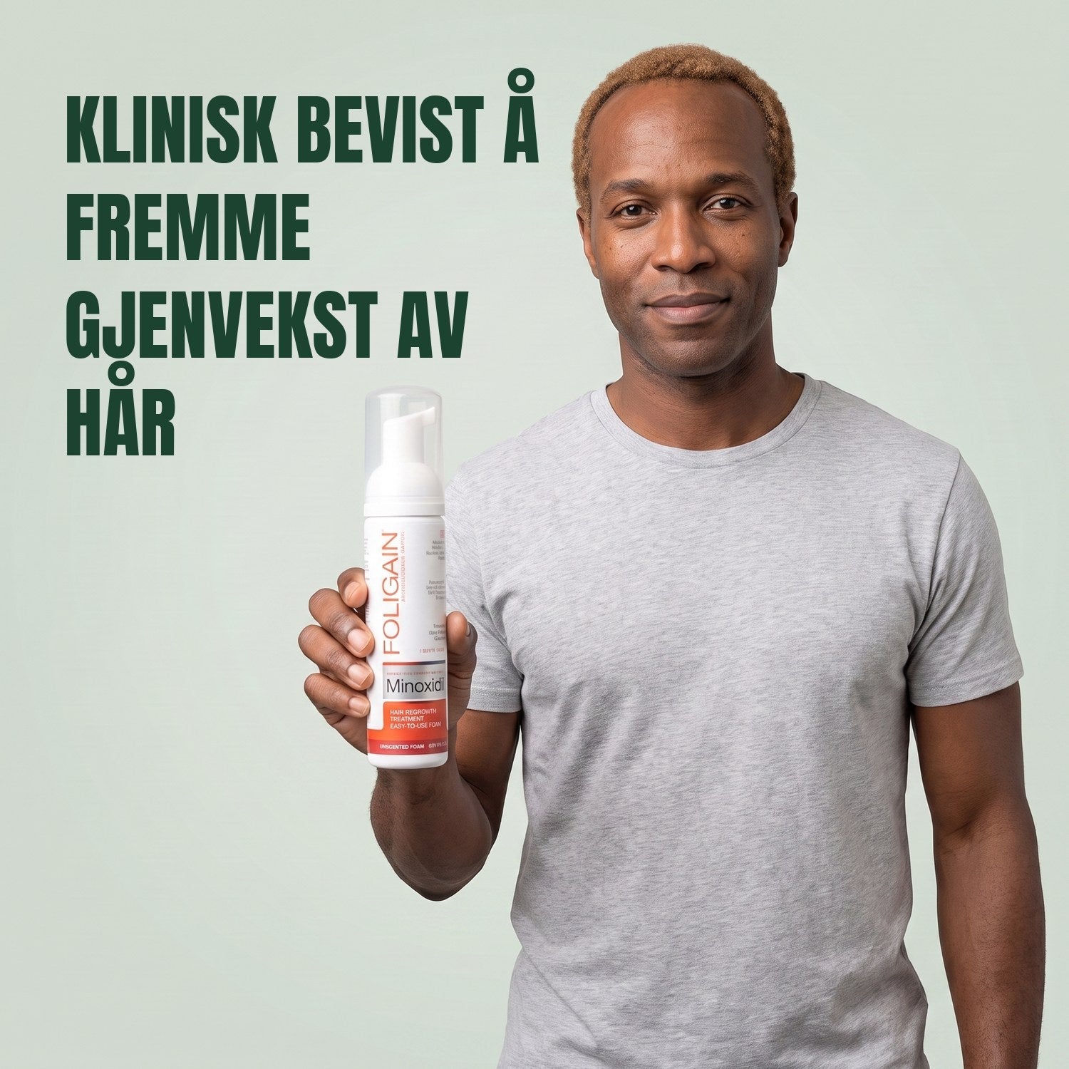 Man holding the Foligain Minoxidil 5% foam can for men against a green background
