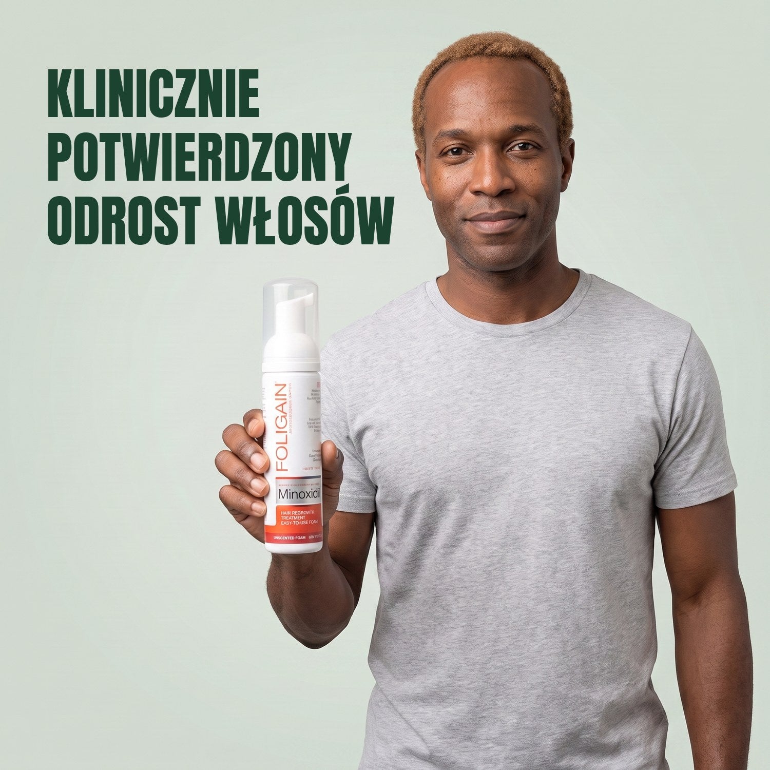 Mężczyzna trzyma puszkę pianki Foligain Minoxidil 5% dla mężczyzn na zielonym tle
