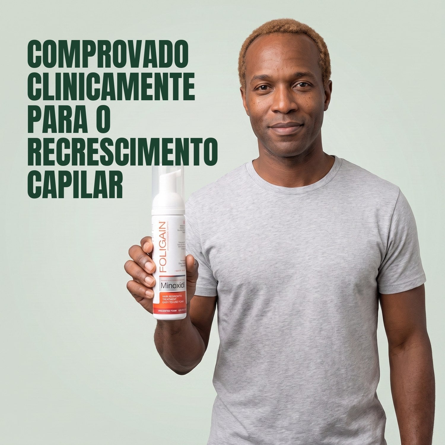 Homem segurando a lata de espuma Foligain Minoxidil 5% para homens em fundo verde