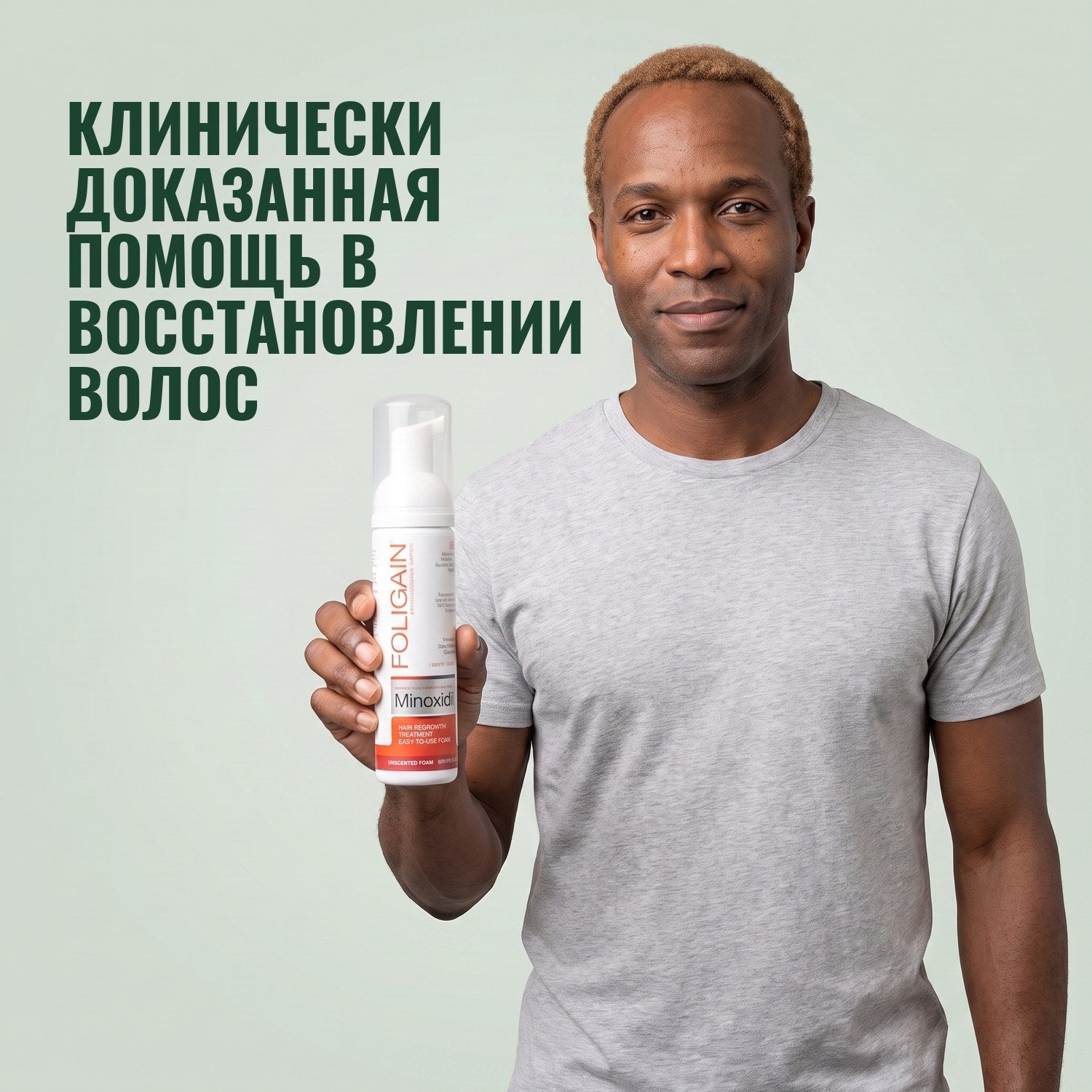 Man holding the Foligain Minoxidil 5% foam can for men against a green background