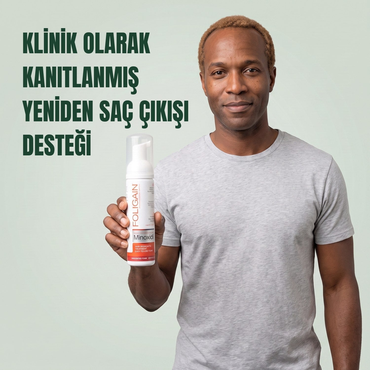 Man holding the Foligain Minoxidil 5% foam can for men against a green background