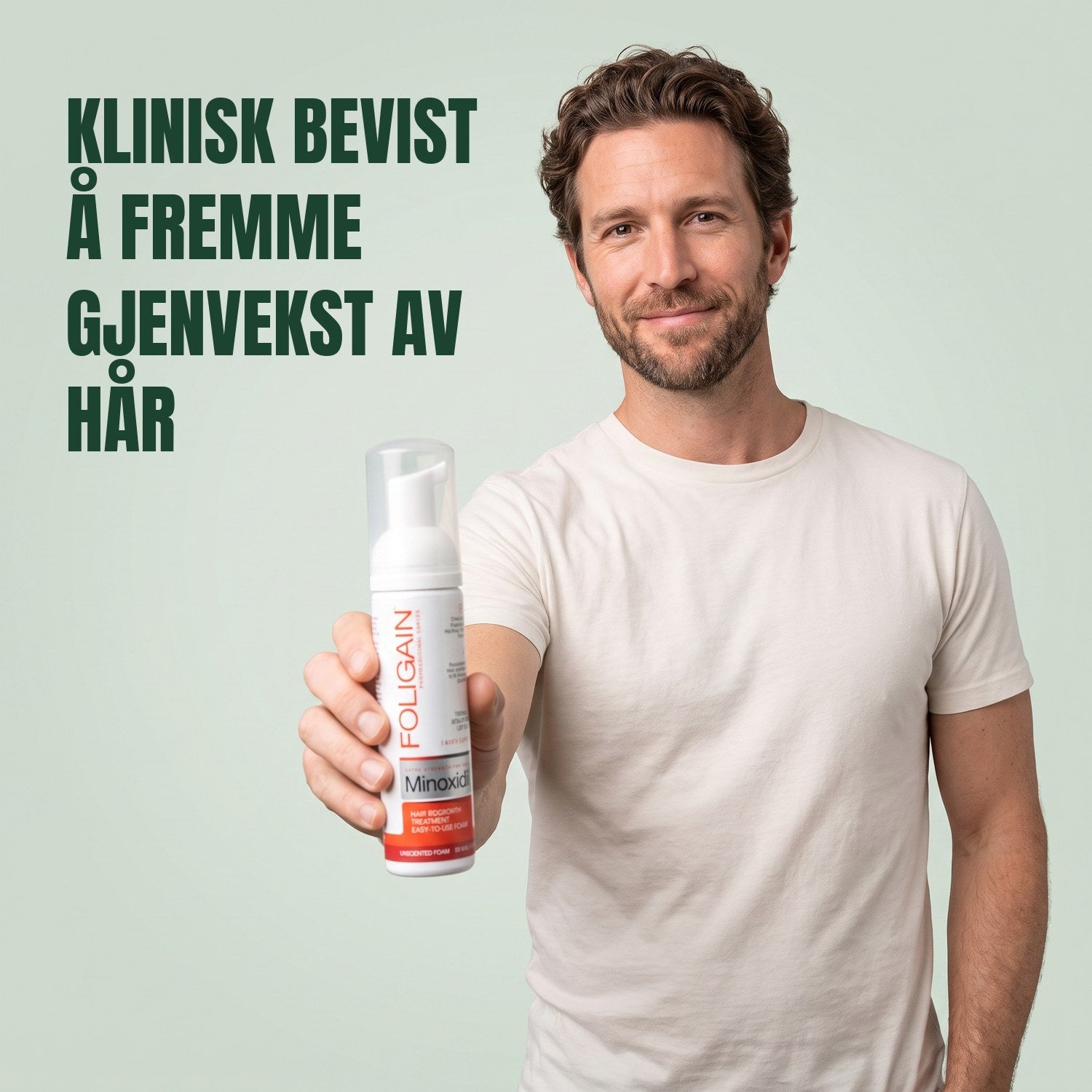 Mann som holder Foligain Minoxidil 5 % skum for menn mot en grønn bakgrunn