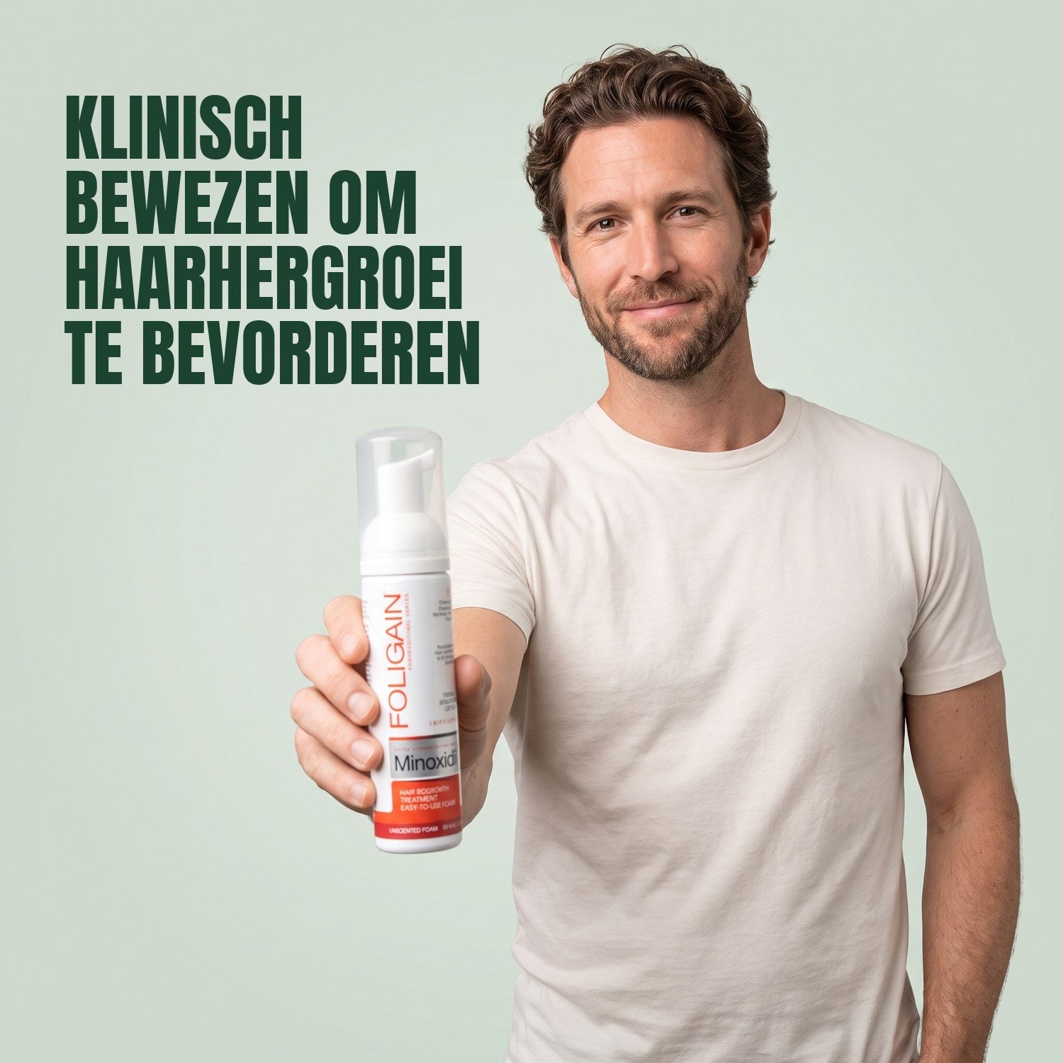 Man holding Foligain Minoxidil 5% foam for men against a green background
