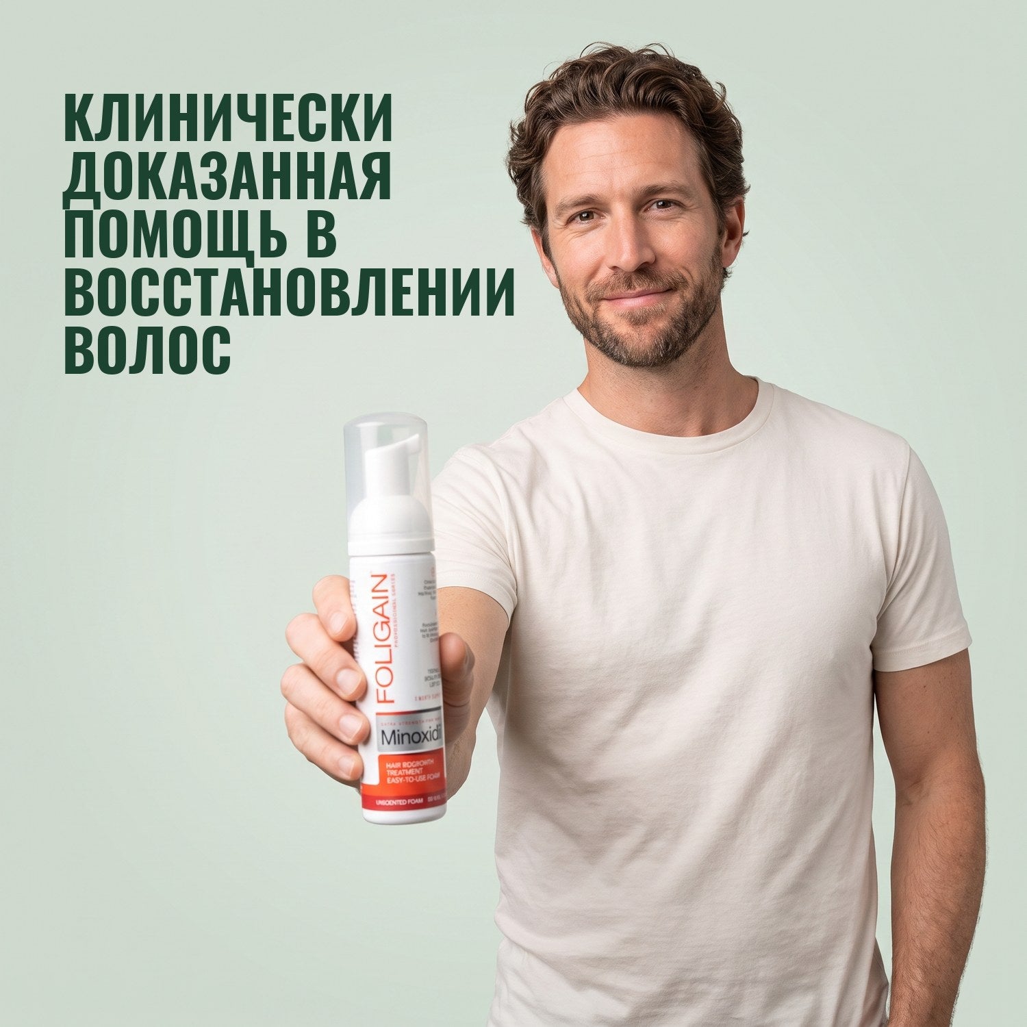 Мужчина держит пену Foligain с миноксидилом 5% для мужчин на зелёном фоне