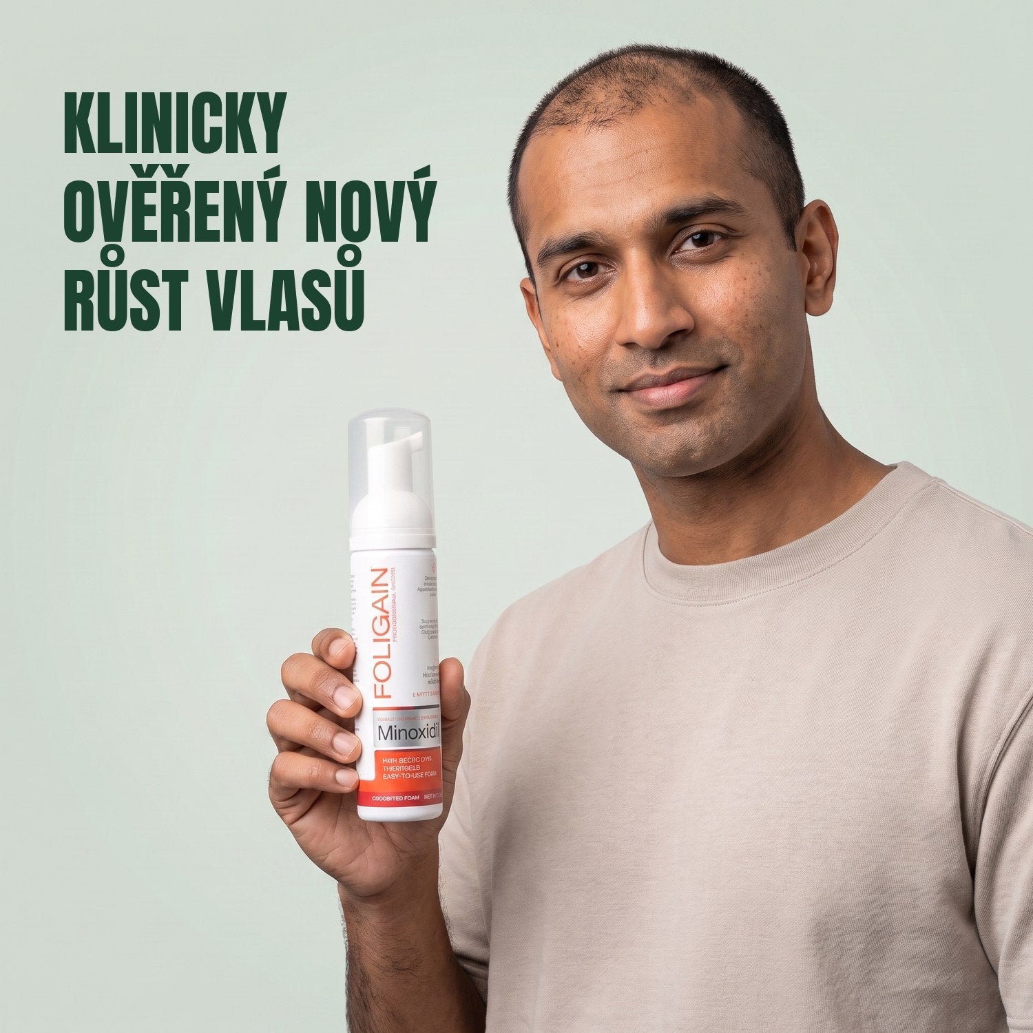 Muž drží plechovku pěny Foligain Minoxidil 5% pro muže na zeleném pozadí