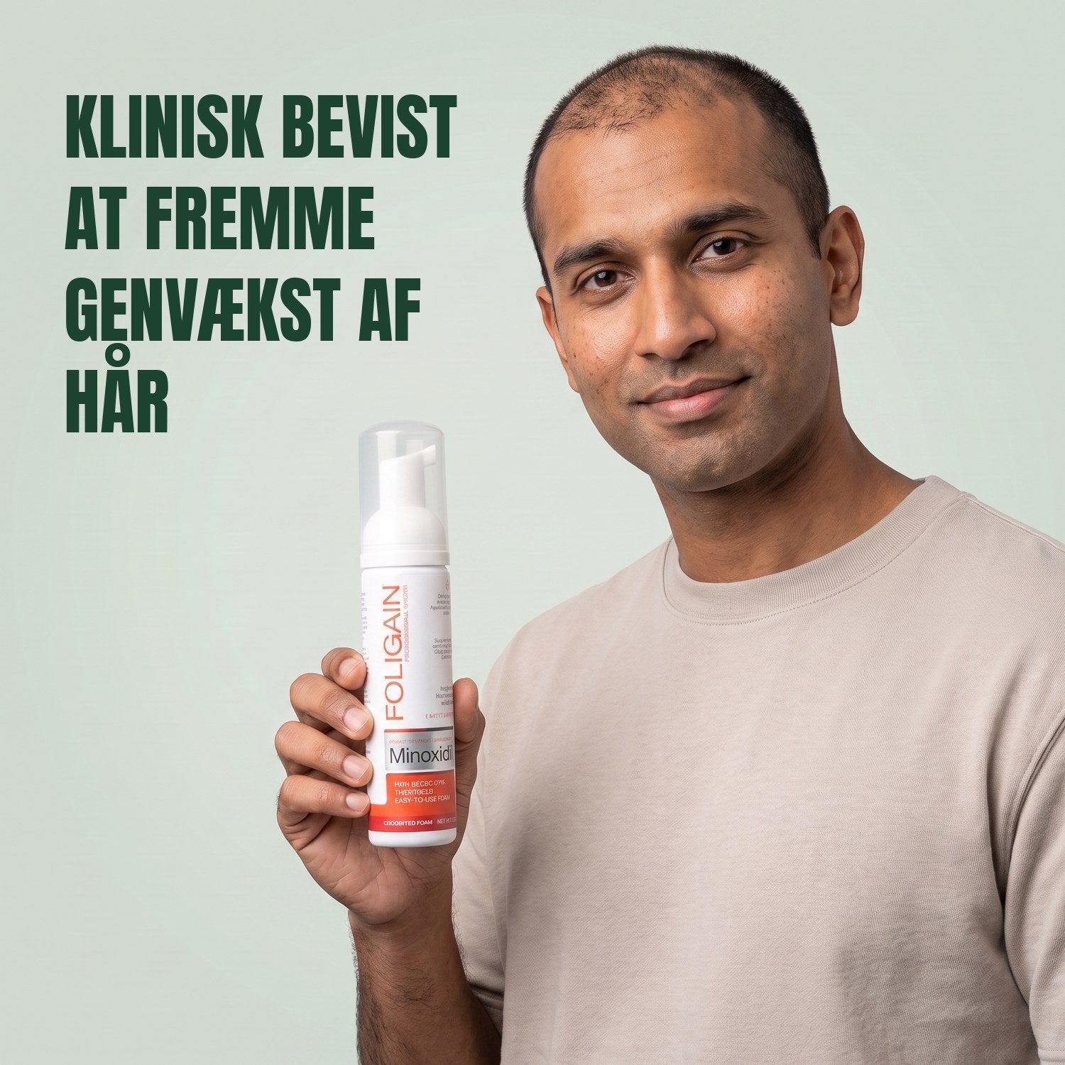 Man holding the Foligain Minoxidil 5% foam can for men against a green background