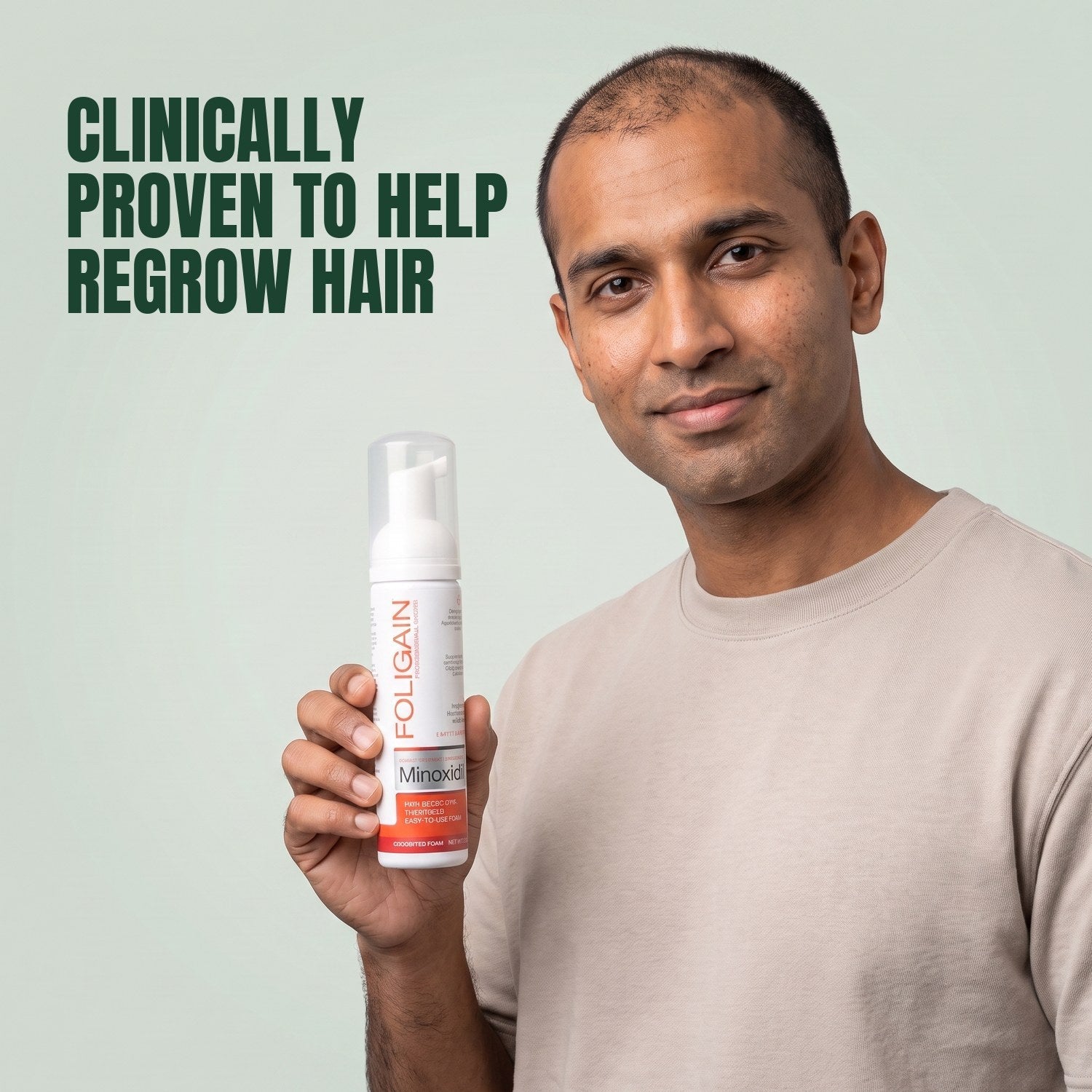 Man holding the Foligain Minoxidil 5% foam can for men against a green background