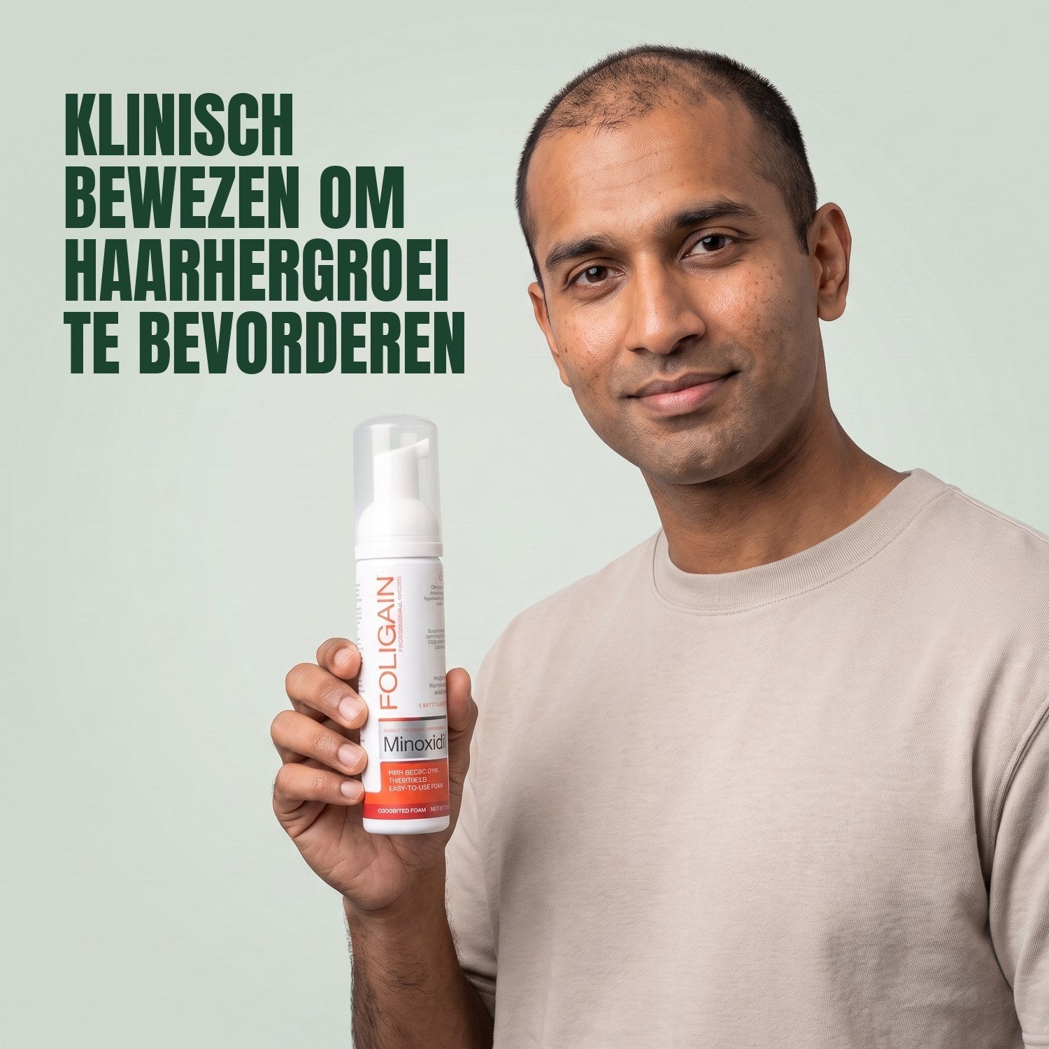 Man holding the Foligain Minoxidil 5% foam can for men against a green background