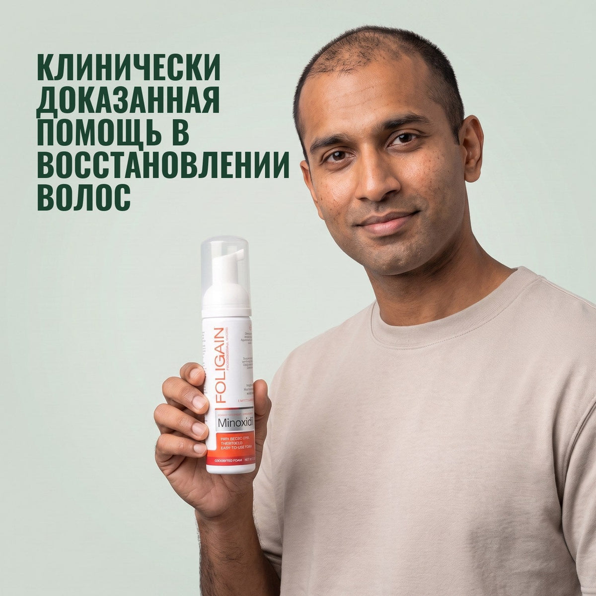 Man holding the Foligain Minoxidil 5% foam can for men against a green background