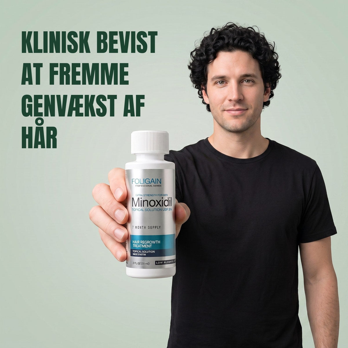 Man holding the Foligain Minoxidil 5% sensitive skin lotion bottle for men against a green background