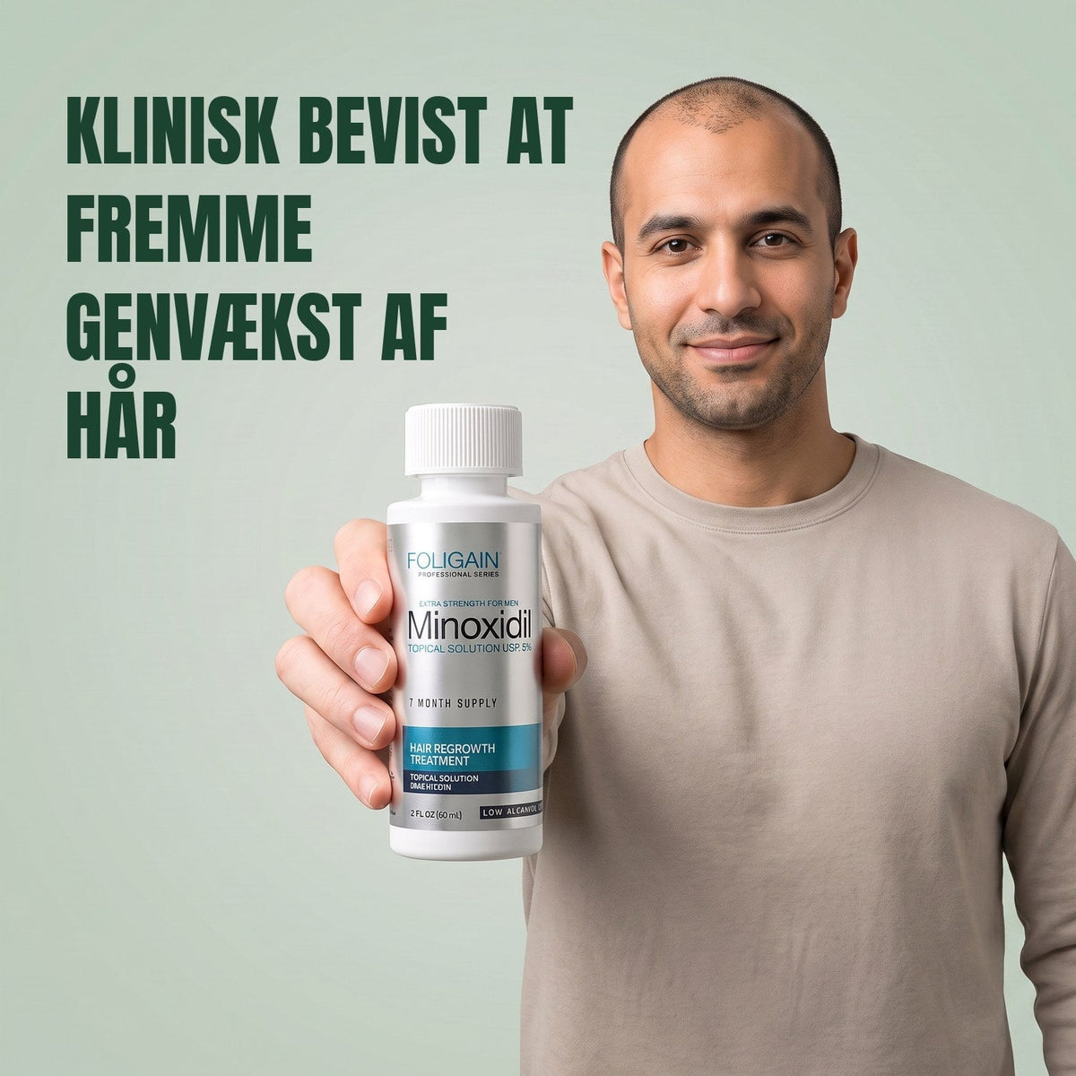 Man holding the Foligain Minoxidil 5% sensitive skin lotion bottle for men against a green background