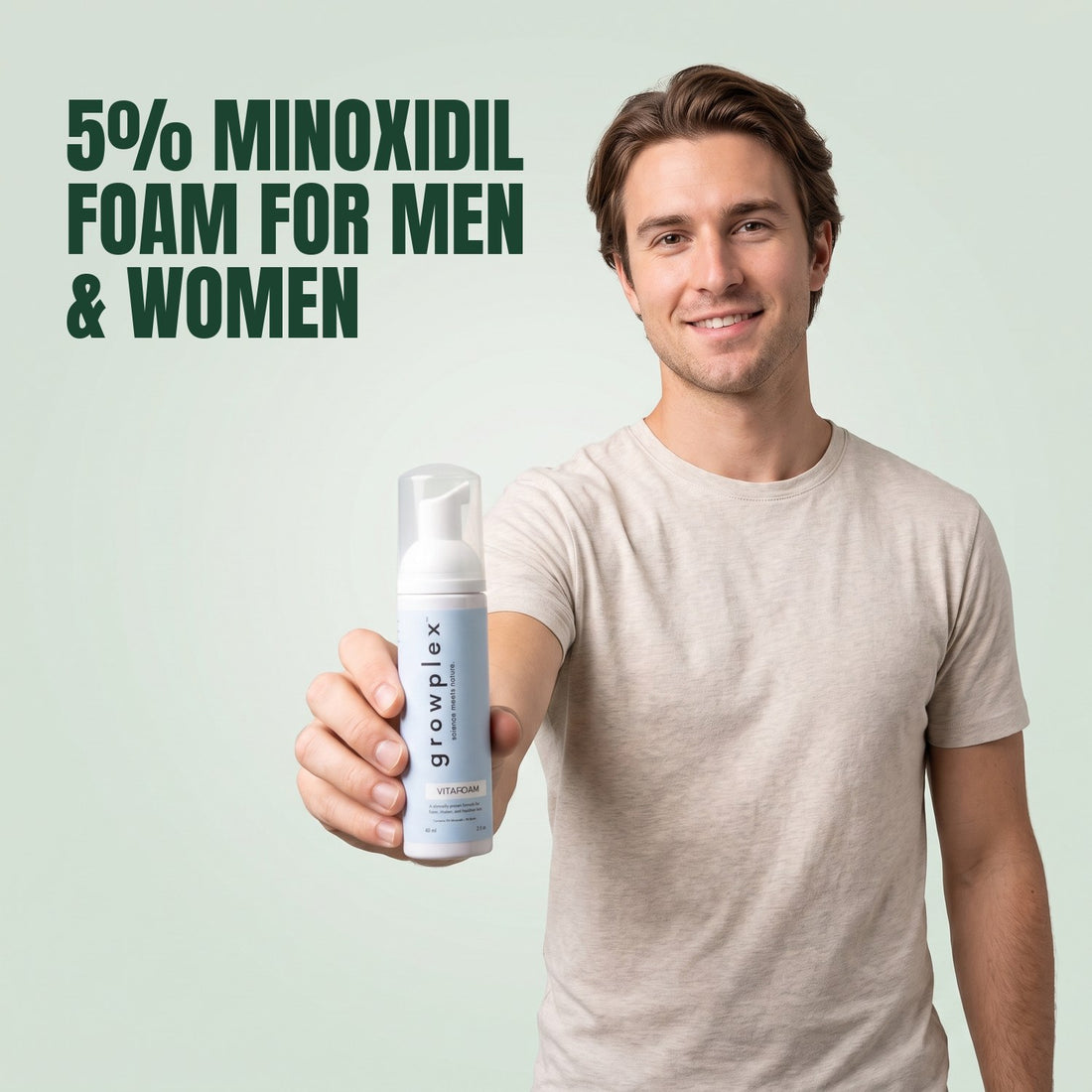 Man holding a Growplex VitaFoam minoxidil 5% foam bottle against a green background