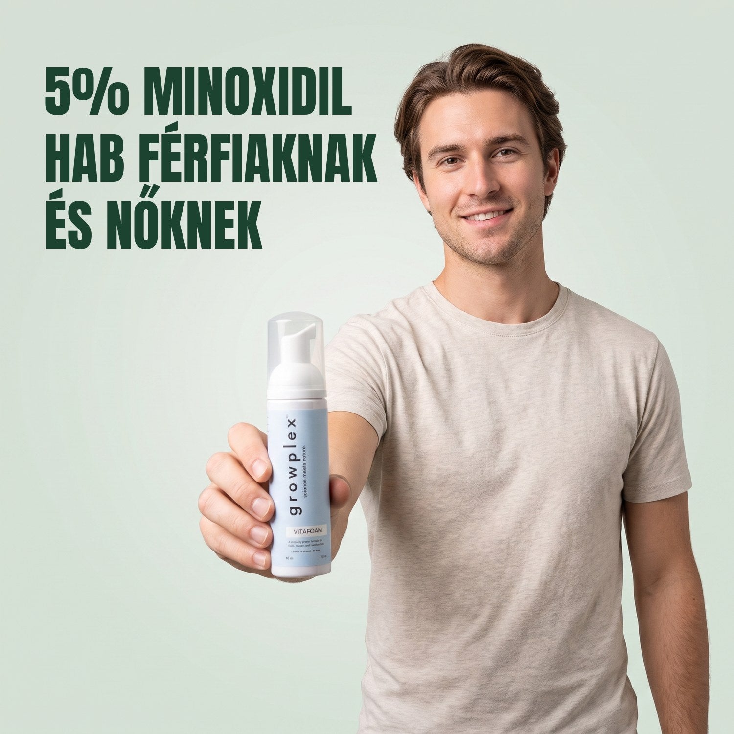 Férfi a Growplex VitaFoam minoxidil 5% hab flakonját tartja zöld háttér előtt