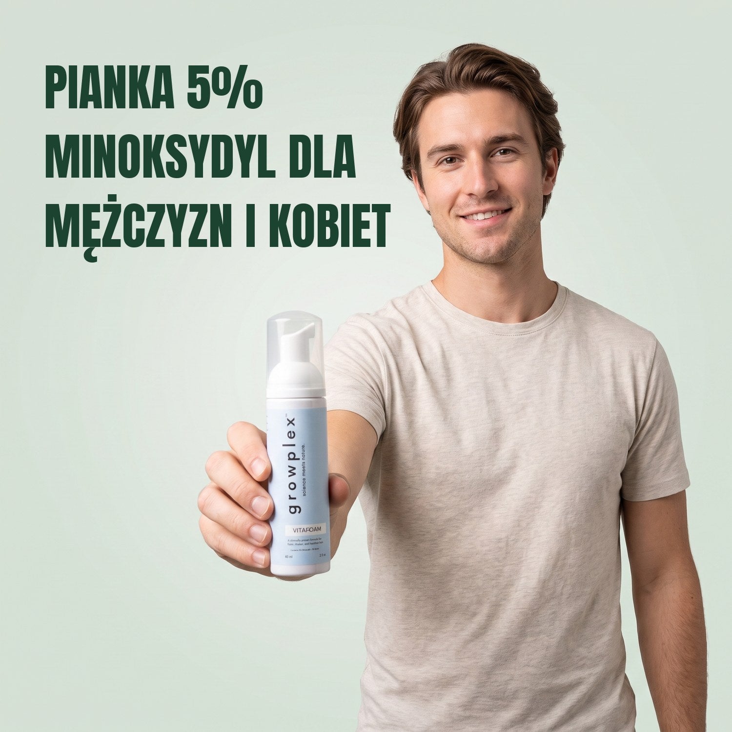 Mężczyzna trzyma butelkę pianki Growplex VitaFoam minoxidil 5% na tle zielonego tła