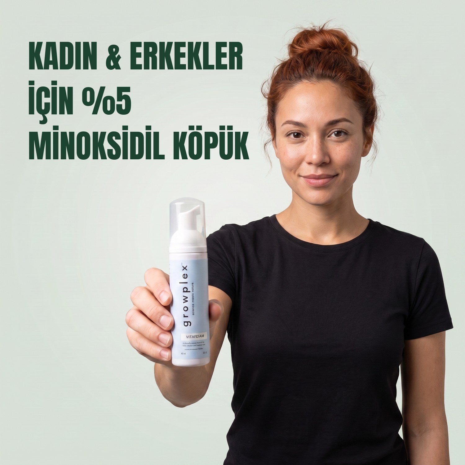Woman holding the Growplex VitaFoam minoxidil 5% foam bottle against a green background