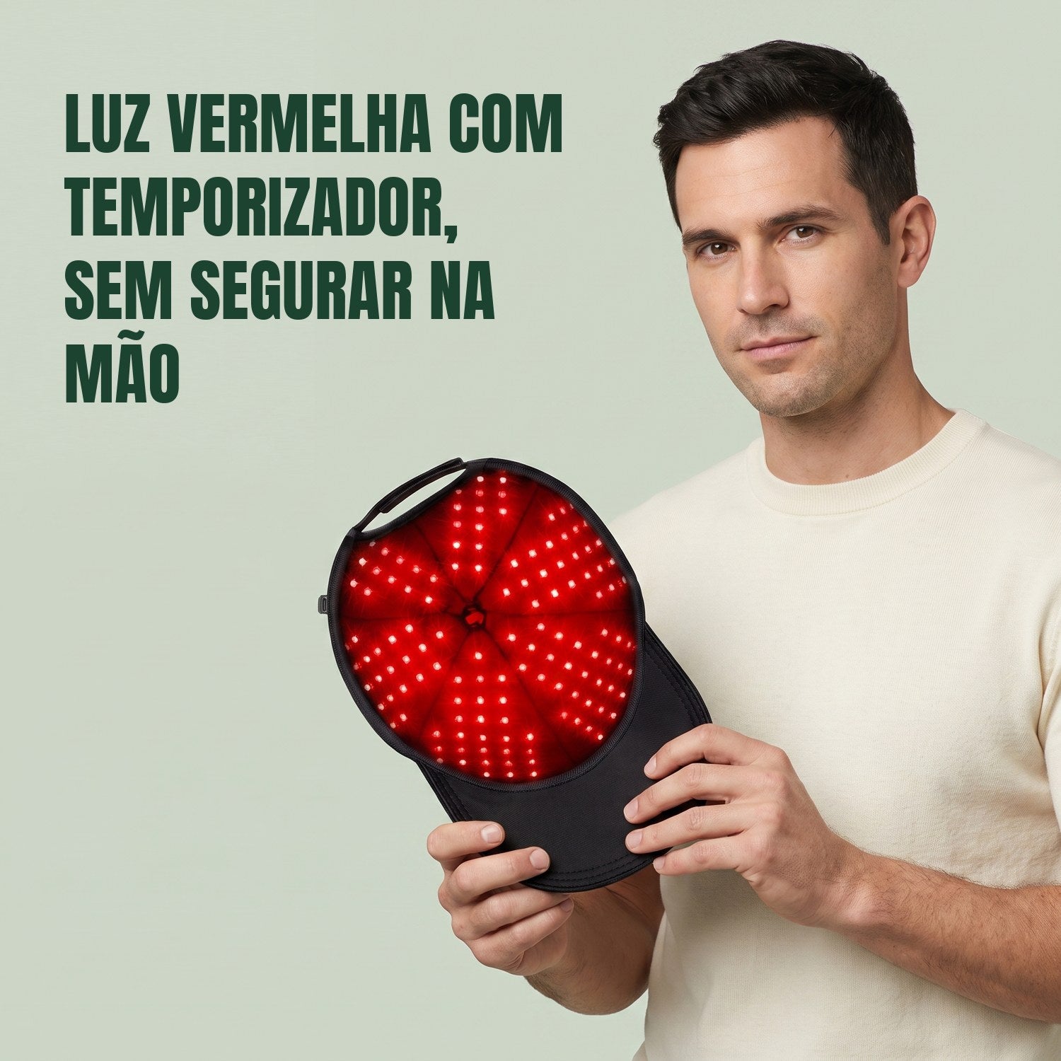 Homem segurando a touca infravermelha para crescimento capilar contra um fundo verde