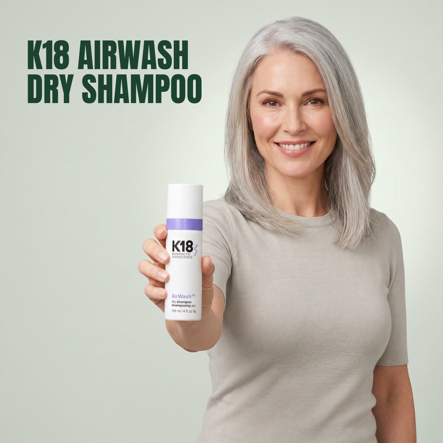 Woman holding K18 AirWash Dry Shampoo against a green background