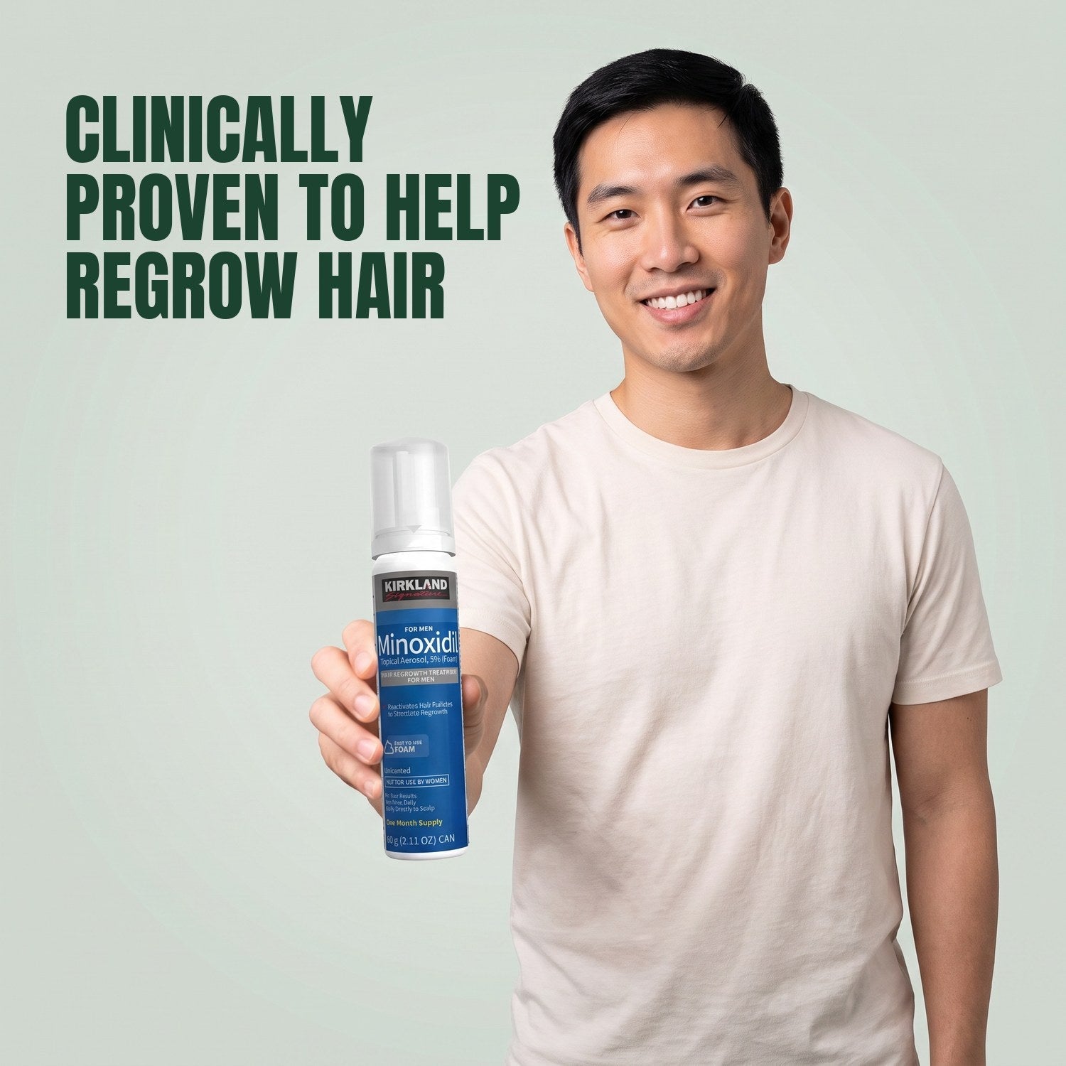Man holding a Kirkland Signature Minoxidil 5% foam can for men against a green background