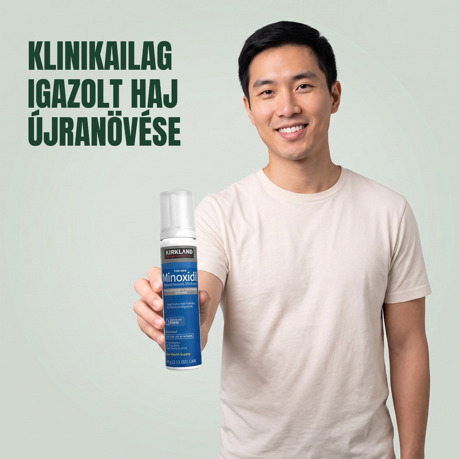 Férfi Kirkland Signature Minoxidil 5% habos dobozzal a kezében, zöld háttér előtt