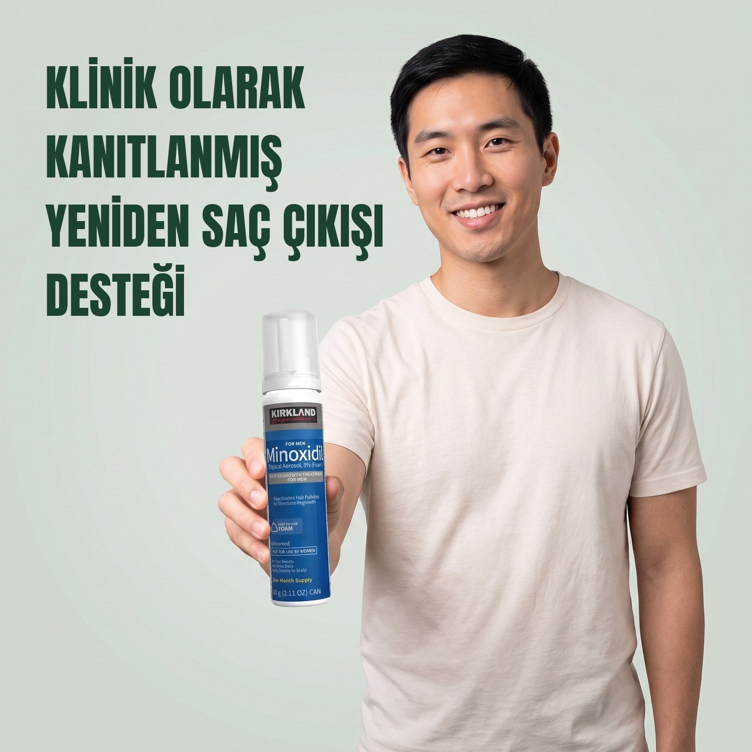 Yeşil arka plan önünde erkekler için Kirkland Signature Minoksidil 5% köpük kutusu tutan adam
