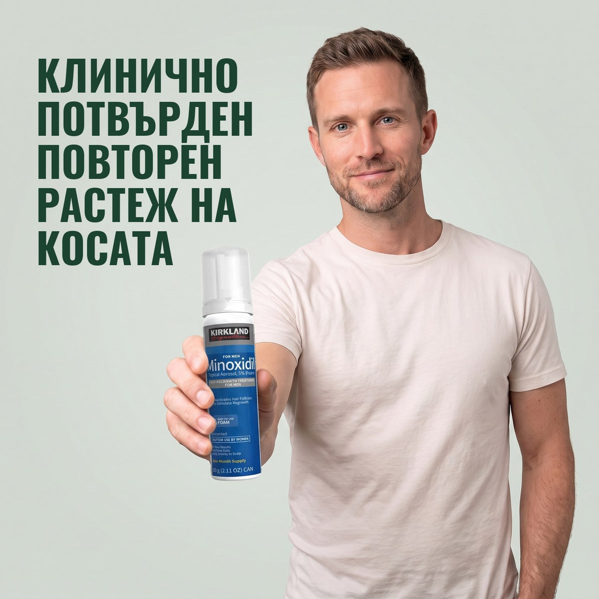 Мъж държи кутия Kirkland Signature миноксидил 5% пяна за мъже на зелен фон