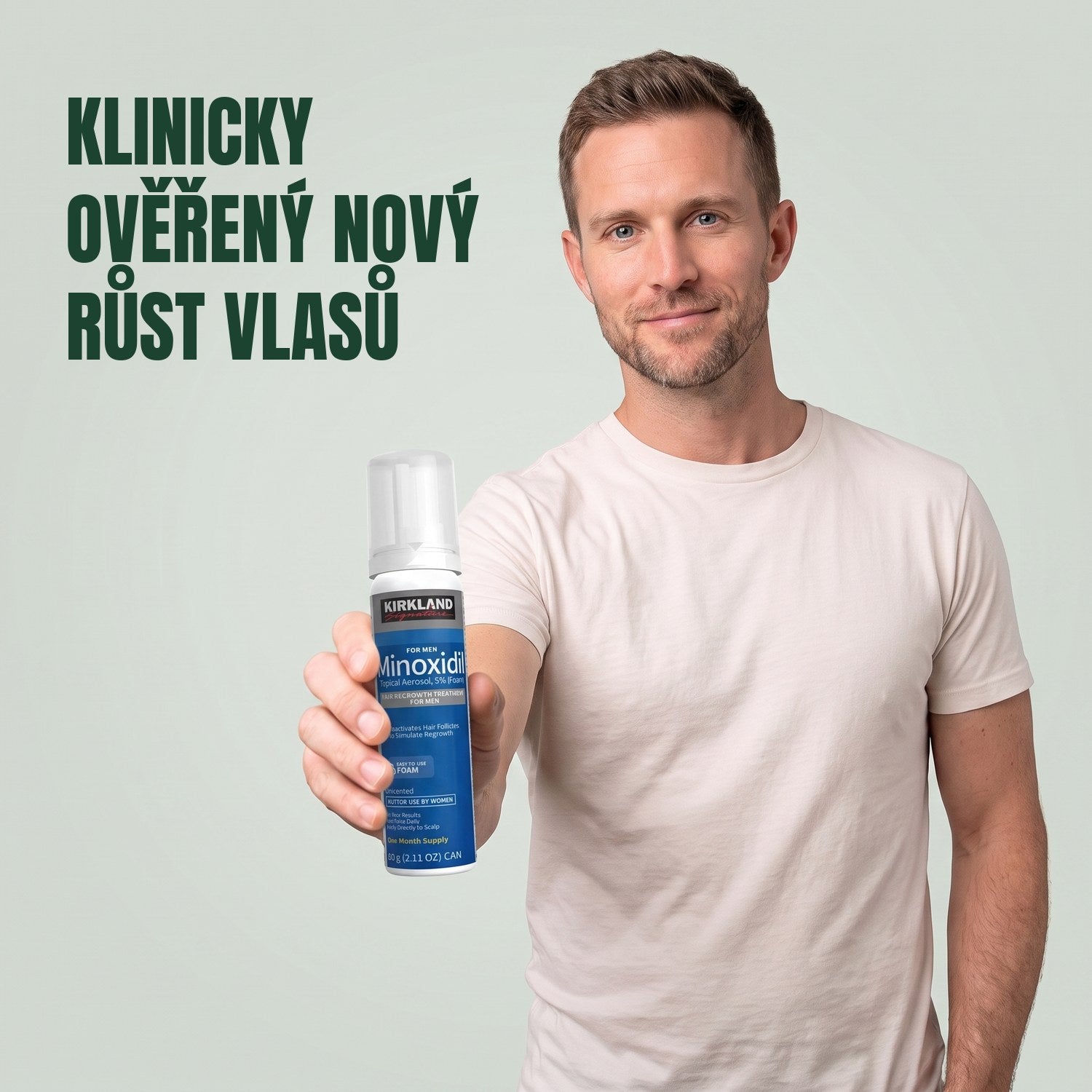 Muž drží plechovku Kirkland Signature Minoxidil 5% pěna pro muže na zeleném pozadí