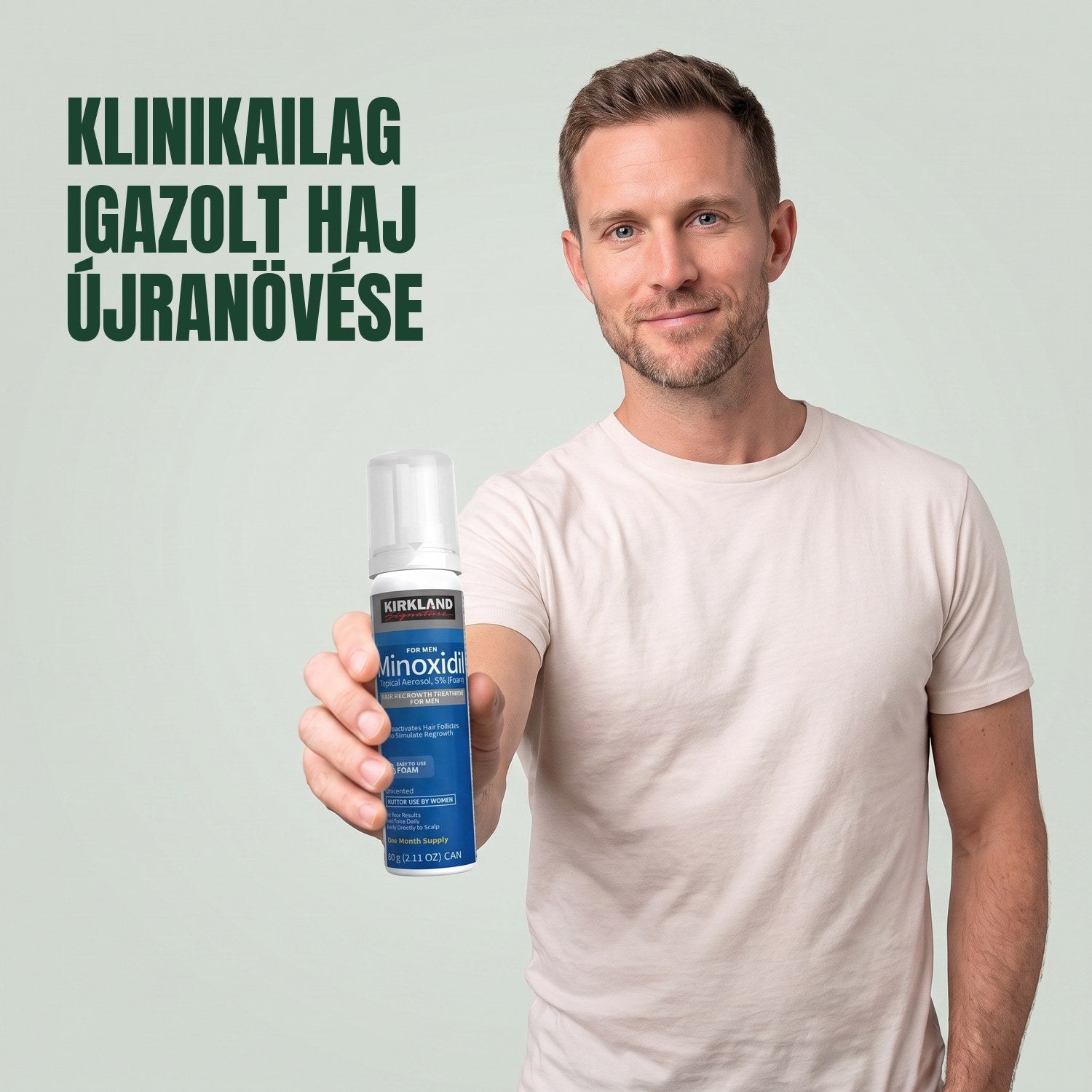 Férfi Kirkland Signature Minoxidil 5% habos dobozzal a kezében, zöld háttér előtt