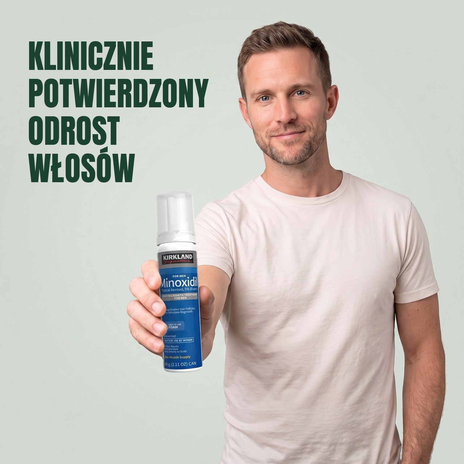 Mężczyzna trzyma puszkę pianki Kirkland Signature Minoxidil 5% dla mężczyzn na zielonym tle