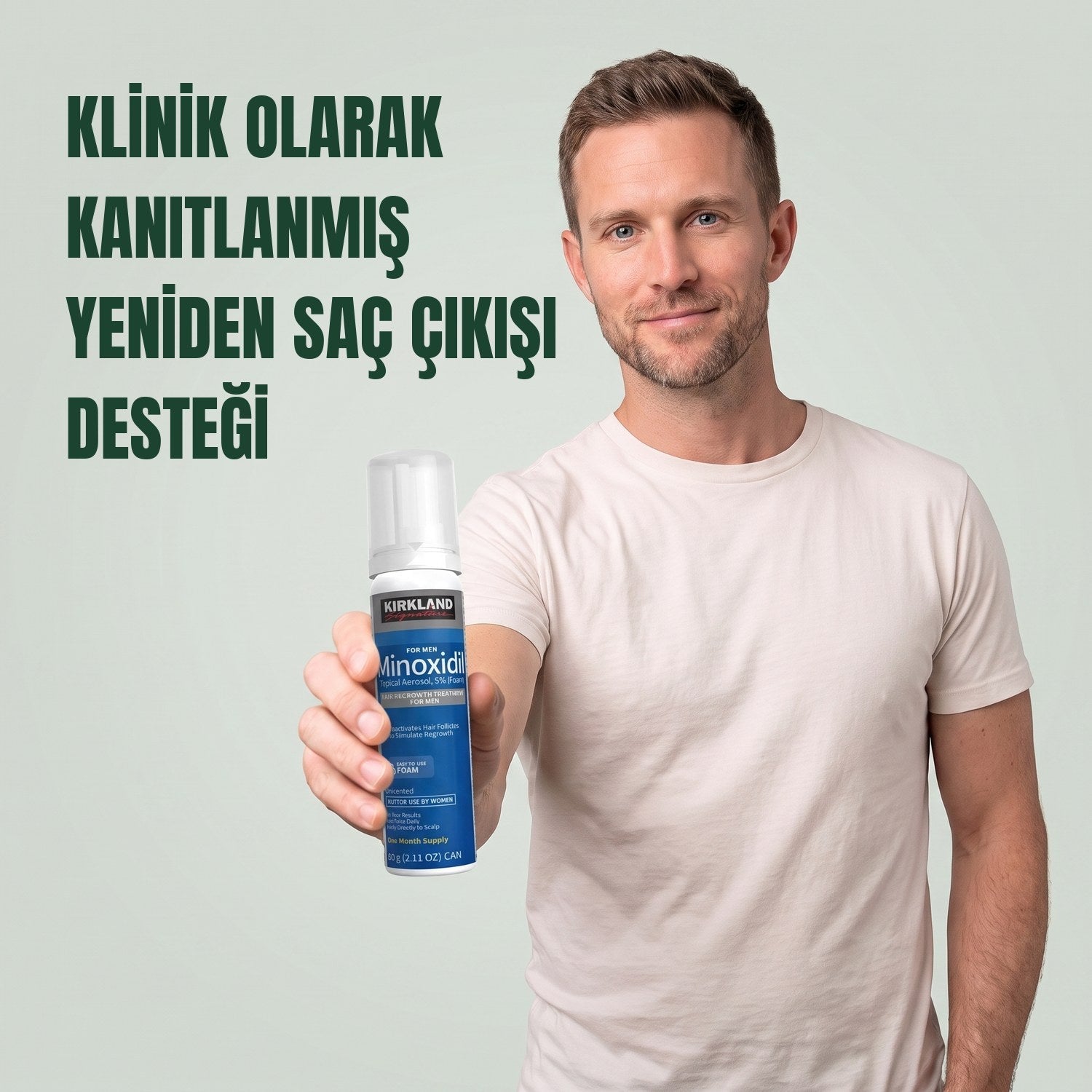 Yeşil arka plan önünde erkekler için Kirkland Signature Minoksidil 5% köpük kutusu tutan adam