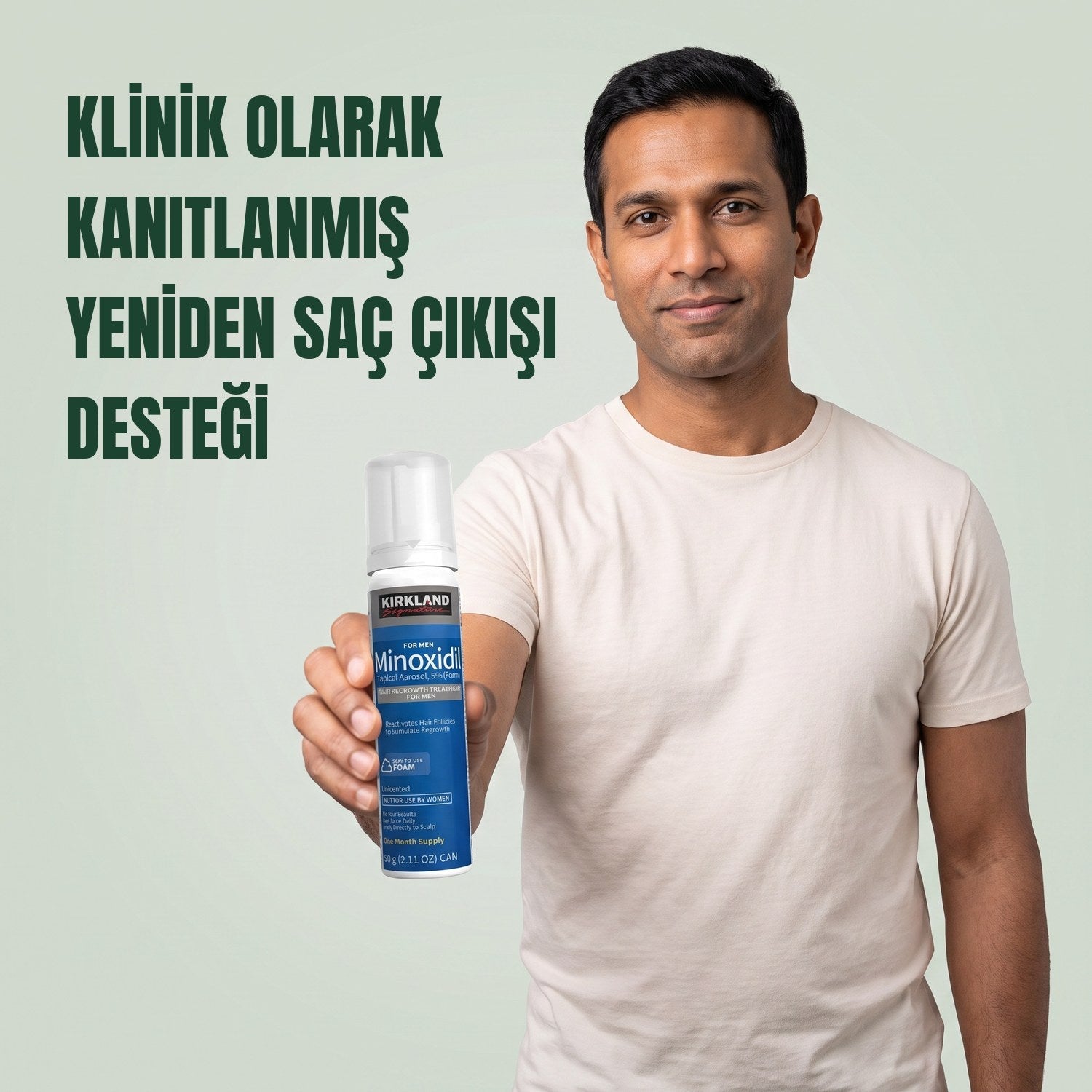Yeşil arka plan önünde erkekler için Kirkland Signature Minoksidil 5% köpük kutusu tutan adam