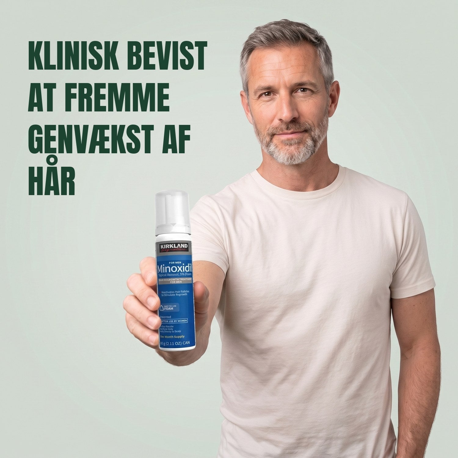 Mand holder en Kirkland Signature Minoxidil 5% skumdåse til mænd mod en grøn baggrund