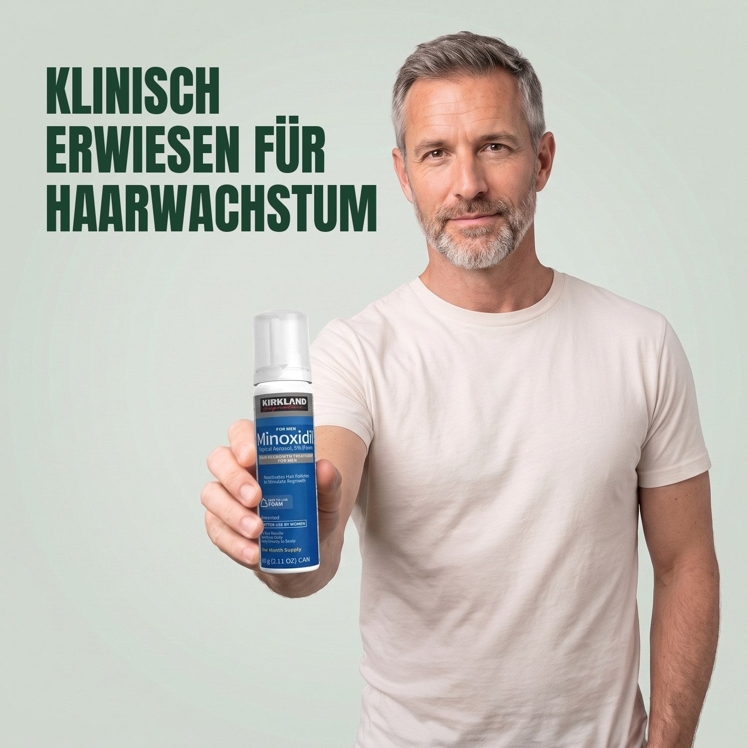 Mann hält eine Dose Kirkland Signature Minoxidil 5% Schaum für Männer vor grünem Hintergrund