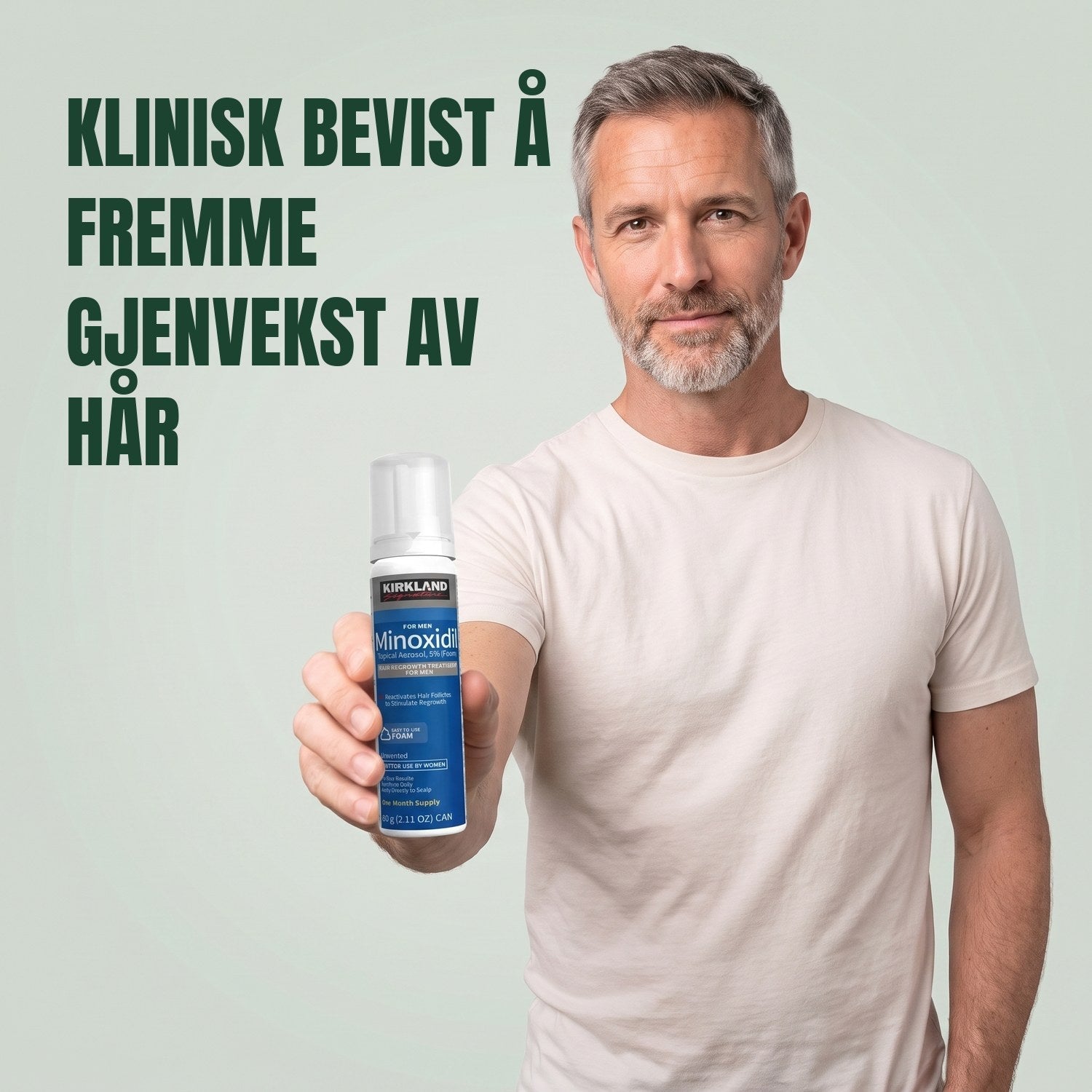 Mann holder en boks med Kirkland Signature Minoxidil 5% skum for menn mot en grønn bakgrunn