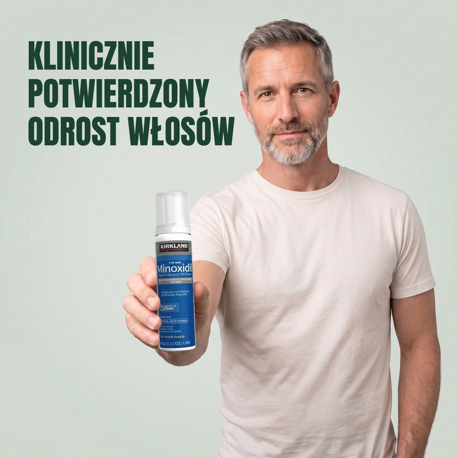 Mężczyzna trzyma puszkę pianki Kirkland Signature Minoxidil 5% dla mężczyzn na zielonym tle