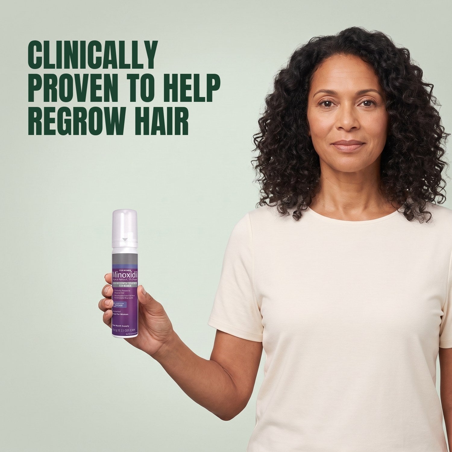 Woman holding a Kirkland Signature Minoxidil 5% foam can for women against a green background